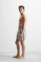 Short de baño blanco con rayas verticales negras y celestes, cintura elástica con cordón ajustable, bolsillos laterales y trasero.