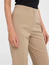 Pantalón sastrero color beige, de corte recto y largo al tobillo.