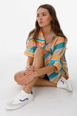 Zapatillas plateadas con cordones blancos y suela blanca.