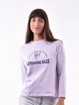 Remera blanca de manga larga con estampa rectangular dorada con diseño animal print y texto 'Fearless, fierce & fabulous'.