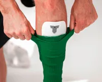 Medias de fútbol verdes con elástico en la parte superior.