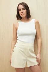 Short color crema de tiro alto con detalle de botones grandes en el lateral.