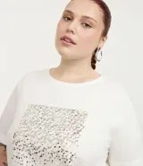 Remera de algodón color blanco con cuello redondo y mangas cortas. Presenta un estampado de lentejuelas con efecto de lluvia en el frente.