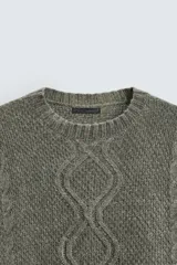 Sweater verde oliva de punto con cuello redondo, manga larga y diseño de trenzas en el frente.