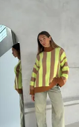 Sweater de punto con cuello alto y mangas largas, con rayas verticales rojas y blancas y puños negros.