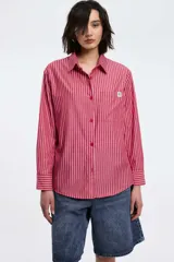 Camisa a rayas verticales rojas y blancas, de corte recto, con cuello clásico, manga larga y bolsillo en el pecho.