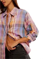 Camisa a cuadros de corte relajado y extragrande, confeccionada en un tejido liviano de algodón. Lleva cuello clásico, cierre frontal con botones y mangas largas con hombros caídos. Los detalles de volantes en los ribetes aportan textura y un toque distintivo, mientras que los puños se ajustan con botón.