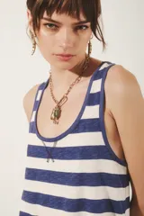 Musculosa a rayas horizontales azules y blancas, con cuello redondo y sisas con ribete azul.