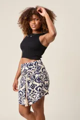 Short pollera con estampado tribal en blanco y azul marino, con lazo decorativo y borlas.
