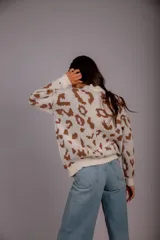 Sweater de punto color crudo con estampado animal print marrón.