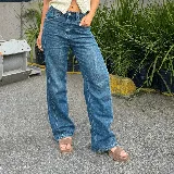 Sandalias de cuero color marrón con plataforma de madera y hebilla dorada.