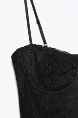 Vestido midi semitransparente de encaje negro, con escote recto, tirantes finos ajustables, forro interior tipo body con aros y abertura lateral en el bajo.