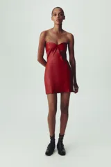 Vestido mini rojo de cuero sintético, con escote corazón y hombros descubiertos.