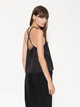 Top negro confeccionado en tela de punto con strass, con breteles finitos que se cruzan en la espalda y escote tipo halter.