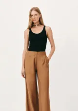 Musculosa slim color ocre, de tela acanalada con cuello redondo y sisas anchas.
