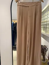 Pantalón de vestir ancho color tostado, con talle alto elástico y pinzas frontales. Incluye un cinturón de la misma tela que se anuda en la cintura.