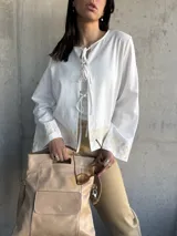 Chaqueta blanca de algodón con bordados florales en puños y ruedo, escote con lazos y mangas largas acampanadas.