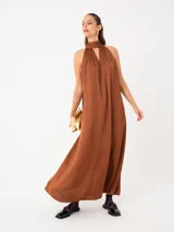Vestido largo negro con cuello halter y lazo en la espalda, confeccionado en viscosa suave y ligera.
