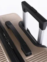 Valija rígida de 24 pulgadas color beige con textura acanalada vertical. Cuenta con manija telescópica superior, manija lateral, cuatro ruedas dobles con giro de 360 grados y candado de seguridad integrado.