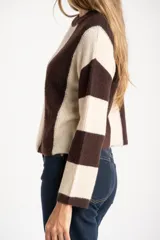 Sweater de tejido de punto grueso, con diseño de rayas verticales anchas en tonos marrón oscuro y negro. Presenta cuello redondo y mangas largas.