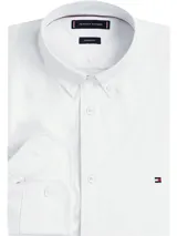 Camisa blanca de corte regular, confeccionada en tejido Oxford Dobby de mezcla de algodón. Tiene cuello abotonado, cierre con botones, manga larga y logo de Tommy Hilfiger bordado en el pecho.
