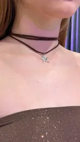 Gargantilla doble de gamuza marrón con dije de estrella plateada.