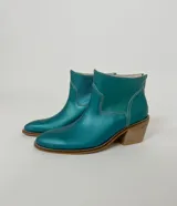 Botas cortas de cuero color turquesa con costuras blancas y taco de madera.