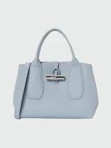 Bolso Longchamp modelo Le Roseau, color celeste, con doble asa corta, cierre con broche metálico y detalles de cuero.