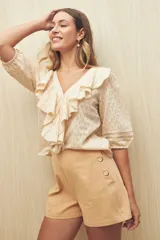 Short color crema de tiro alto con detalle de botones grandes en el lateral.