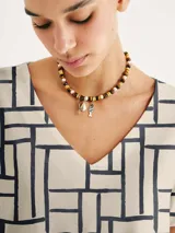 Blusa de cuello en V con estampado geométrico de líneas blancas sobre fondo azul marino.