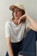 Remera blanca de algodón liviano, de manga corta y cuello redondo. Presenta costuras a contratono visibles en mangas y hombros.