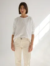 Remera blanca de silueta relajada con cortes geométricos en el frente y costuras a la vista.