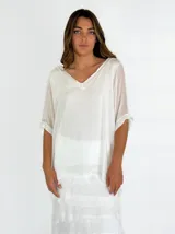 Blusa blanca de mangas cortas con cuello en V y corte holgado.