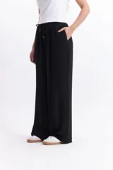 Pantalón negro de tiro alto con elástico y cordón regulable.