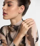 Set de seis anillos dorados de metal con diferentes diseños: uno con detalle de lunar, dos ondulados, uno de cadena, uno con lunar y uno irregular.