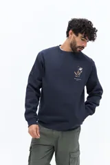 Buzo de algodón azul marino, corte regular, con cuello redondo. Presenta un bordado de flores y texto en el pecho.