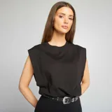 Camiseta negra sin mangas con hombreras marcadas y cuello redondo. Corte recto y holgado.