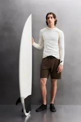 Camiseta de surf compresiva slim fit confeccionada en tejido técnico muy elástico y ligero. Con factor de protección ultravioleta 40+, cuello subido, manga larga, costuras planas y acabados combinados a contraste.