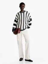 Sweater amplio de lana con rayas verticales azul marino y blanco. Tiene cuello redondo y mangas largas.