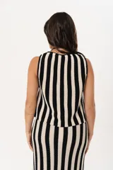 Chaleco tejido a rayas verticales en color negro y crudo, con escote en V y cierre frontal con ganchitos.