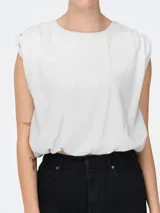 Musculosa blanca de algodón, corte amplio, sin mangas y cuello redondo.
