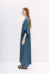 Vestido midi negro de calce amplio y mangas al codo. Tiene apliques de gasa en escote y mangas, y recortes con frunce en la cintura.