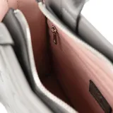 Cartera tipo tote color gris con diseño acolchado en símil cuero. Tiene acceso con cierre, asas fijas y correa regulable extraíble. El interior está forrado en tela de algodón y poliéster y cuenta con un bolsillo con cierre y dos abiertos.