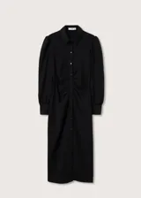 Vestido camisero midi negro con textura de mini rombos, corte entallado, cuello camisero, cierre frontal con botones, mangas largas abullonadas y frunces en la cintura.