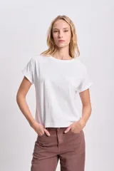 Remera blanca de manga corta con detalle de puntilla en el cuello y las mangas.