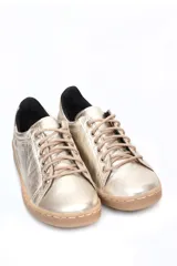 Zapatillas bajas negras de cuero liso, con cordones y suela blanca.