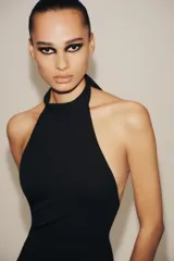 Vestido largo negro, corte recto, con cuello halter que se ata en la nuca y espalda descubierta.