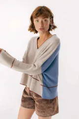 Sweater beige y azul con cuello en V y ribete bordeaux.