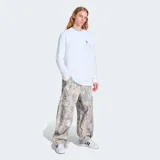 Pantalón cargo de corte ancho (baggy fit) con estampado de camuflaje de hojas en tonos beige, gris y blanco. Presenta bolsillos cargo en los laterales.