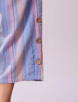 Pantalón capri de algodón a rayas verticales celestes, rosadas y beige. Tiene pretina elastizada, bolsillos delanteros y ruedo con botones.